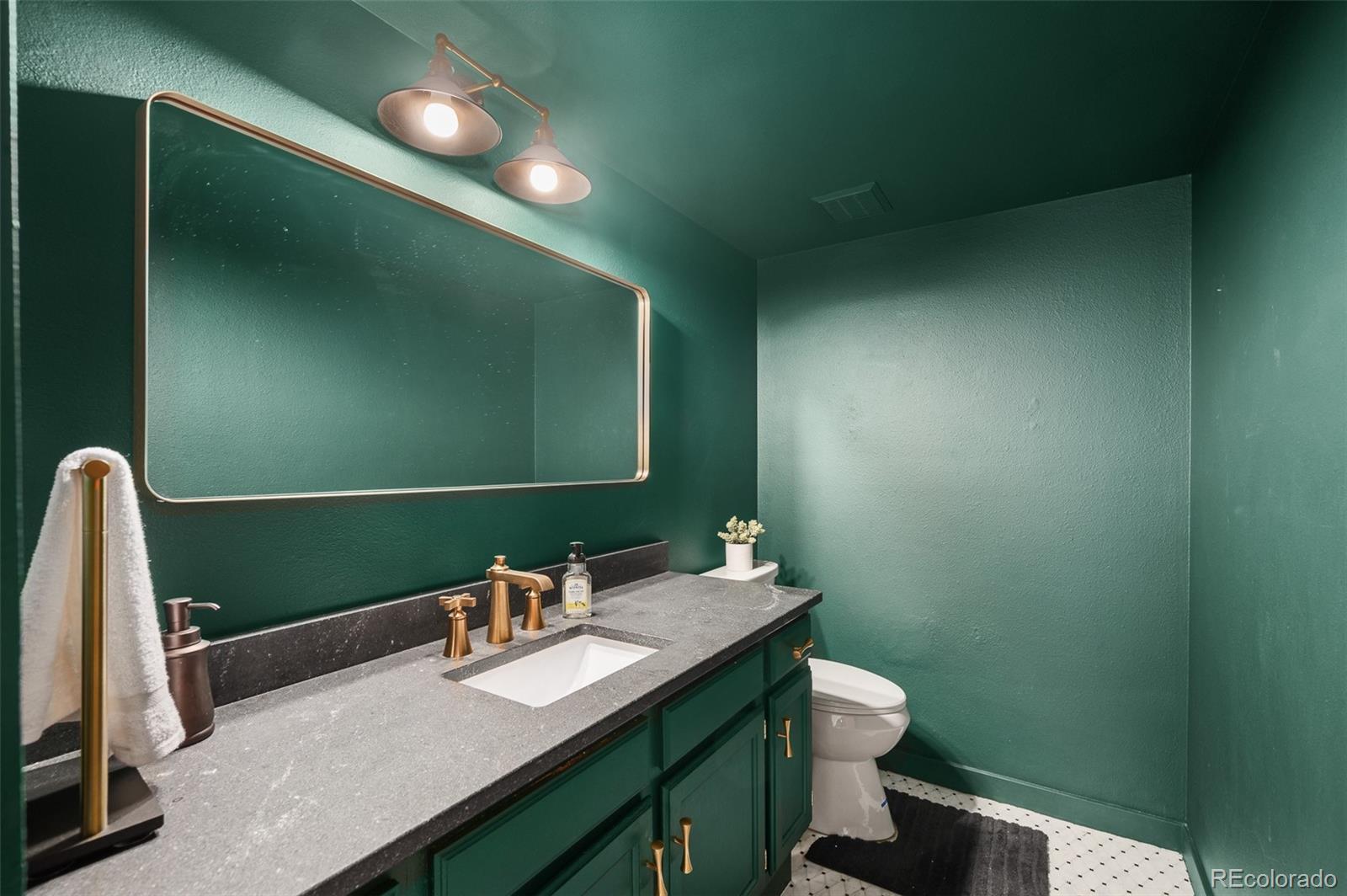 7412 Berkeley Court Castle Pines, CO 80108 - Photo 13 of 37 a bathroom with a sink a toilet and mirror