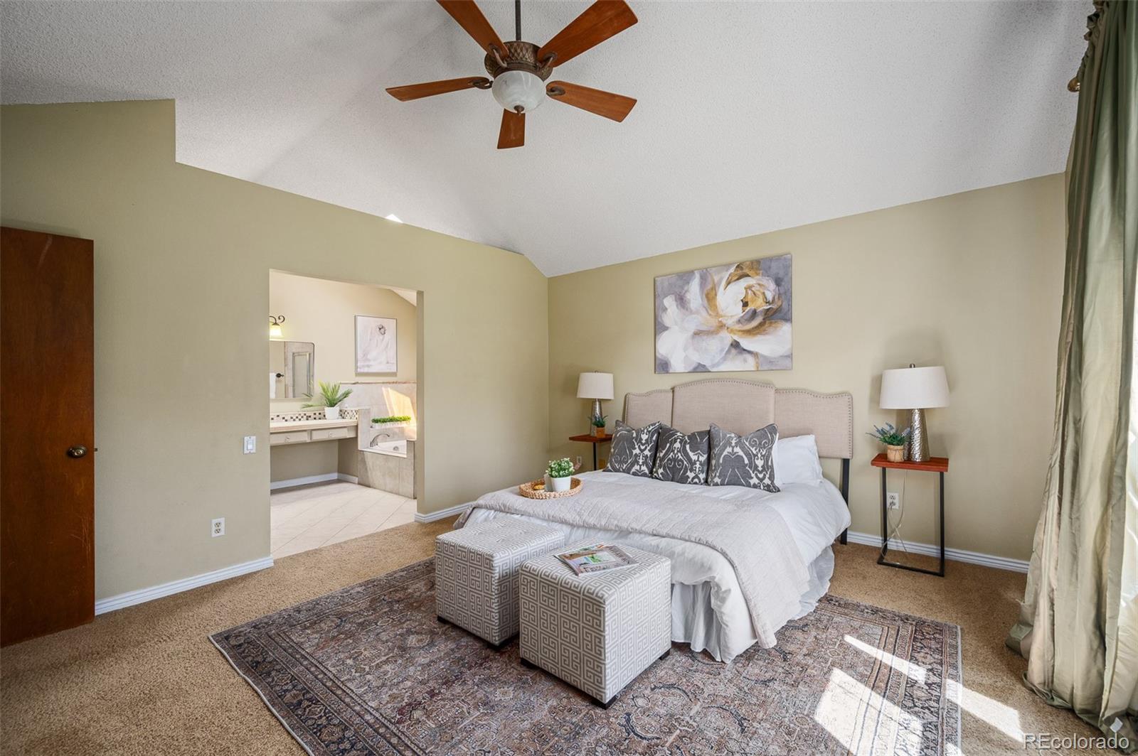 7412 Berkeley Court Castle Pines, CO 80108 - Photo 15 of 37 a bedroom with a large bed and a chandelier