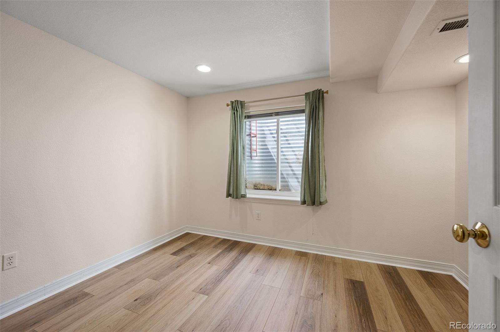 7412 Berkeley Court Castle Pines, CO 80108 - Photo 25 of 37 an empty room with wooden floor and windows