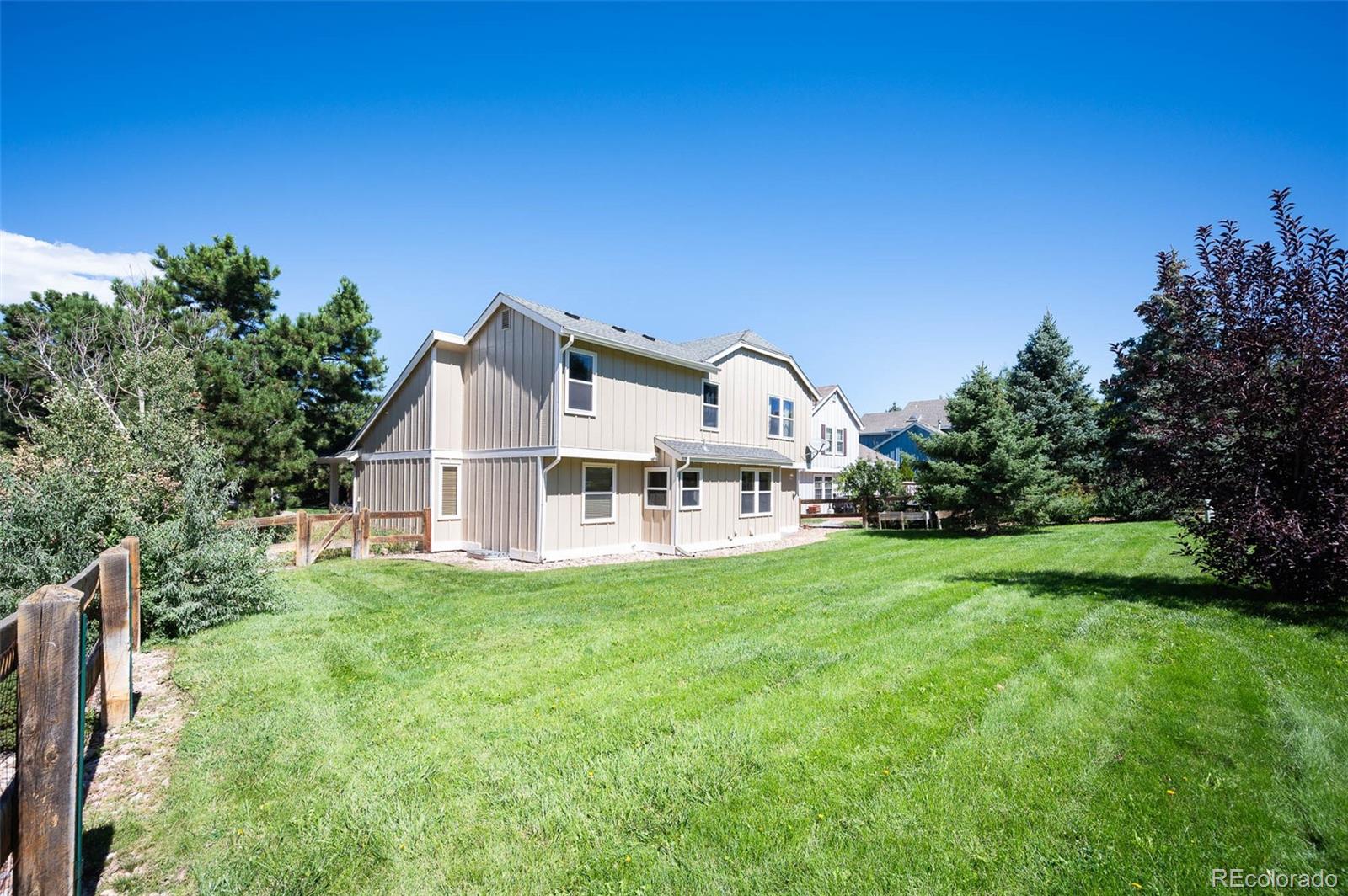 7412 Berkeley Court Castle Pines, CO 80108 - Photo 31 of 37 a view of a house with a yard and deck