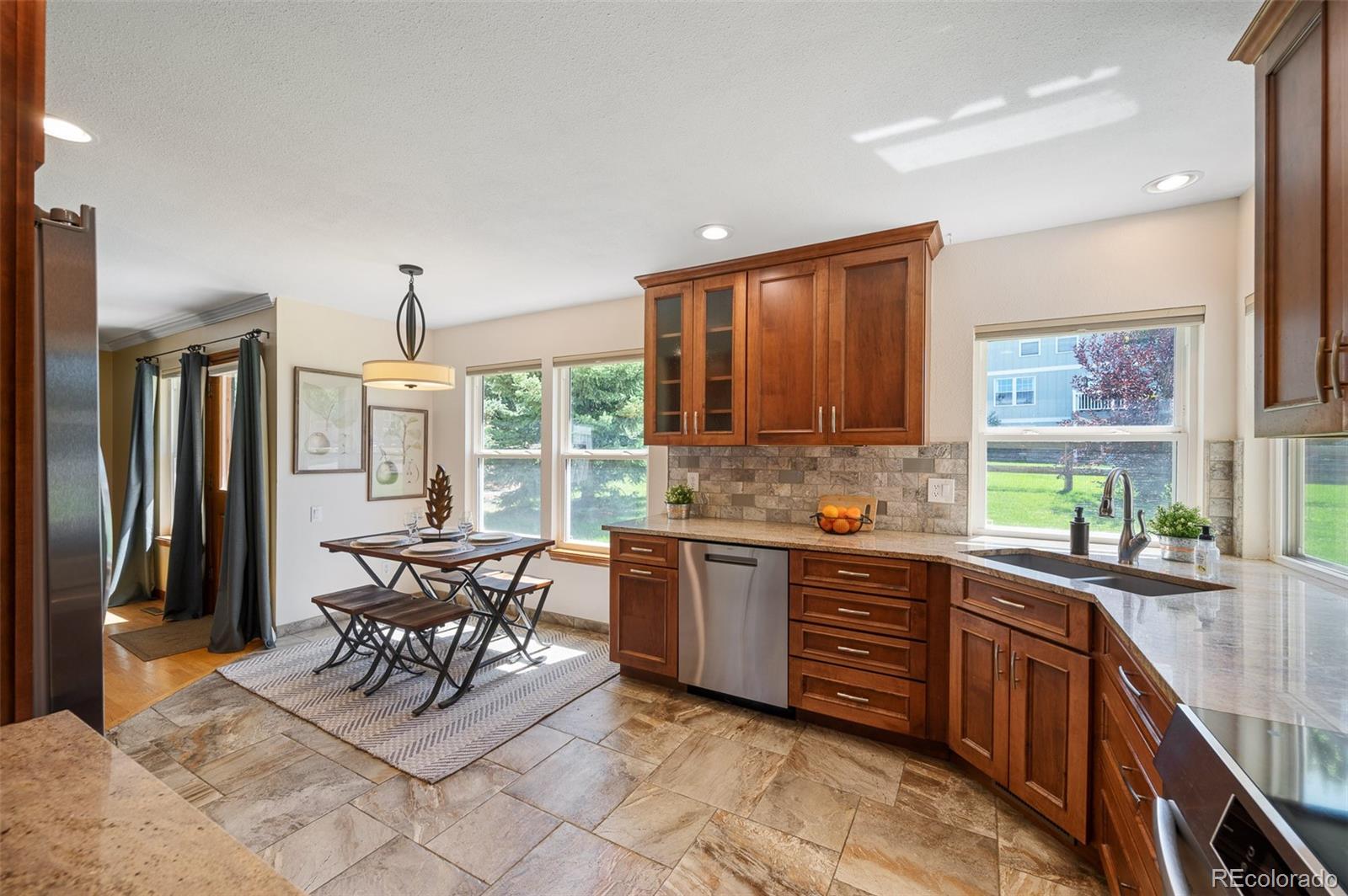 7412 Berkeley Court Castle Pines, CO 80108 - Photo 8 of 37 a kitchen with stainless steel appliances granite countertop table chairs and a large window