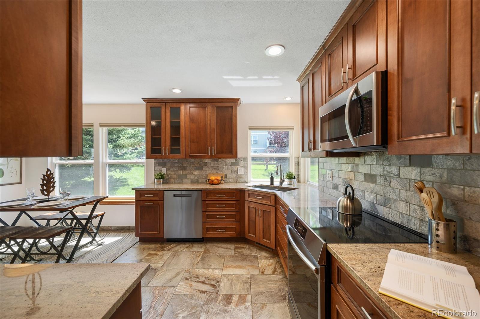 7412 Berkeley Court Castle Pines, CO 80108 - Photo 9 of 37 a kitchen with stainless steel appliances granite countertop a sink and stove