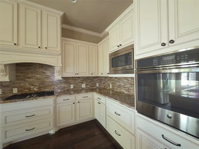 a kitchen with granite countertop white cabinets stainless steel appliances and a sink