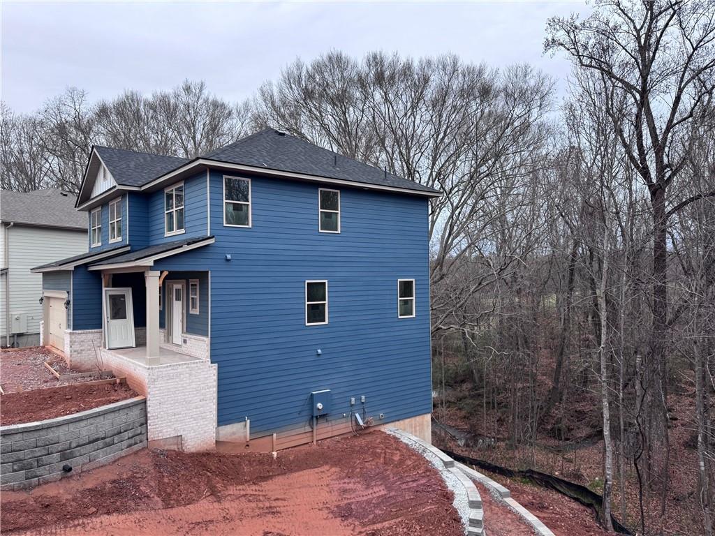 486 Magnolia Grove Place Cornelia, GA 30531 - Photo 3 of 36 a brick house with large windows and a large tree