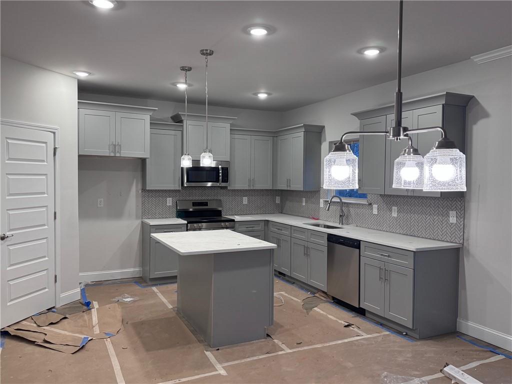 486 Magnolia Grove Place Cornelia, GA 30531 - Photo 4 of 36 a large kitchen with kitchen island a sink stainless steel appliances and cabinets