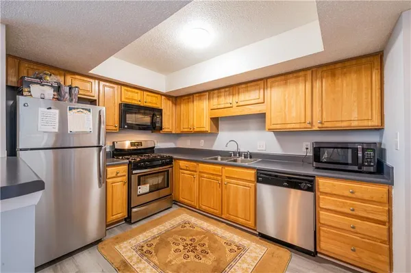 a kitchen with stainless steel appliances granite countertop refrigerator sink and cabinets