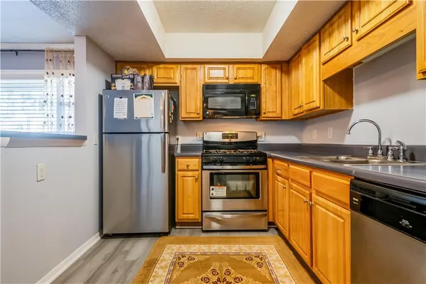 a kitchen with stainless steel appliances granite countertop a refrigerator sink and stove