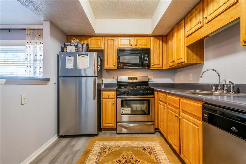 3301 Henderson Mill Road, Unit X4 Atlanta, GA 30341 - Photo 14 of 36 a kitchen with stainless steel appliances granite countertop a refrigerator sink and stove