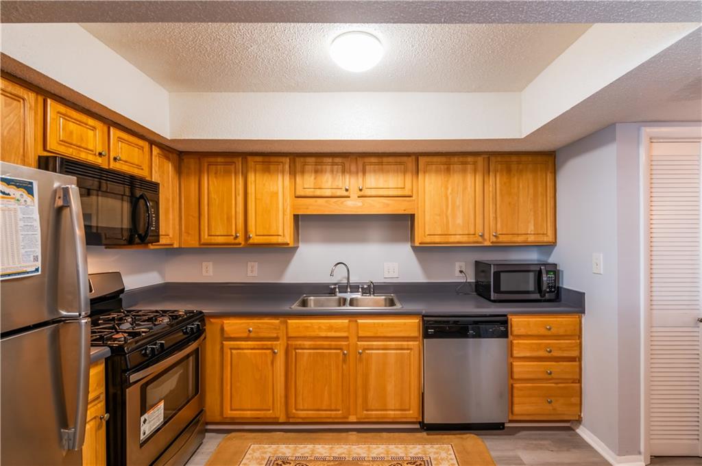 3301 Henderson Mill Road, Unit X4 Atlanta, GA 30341 - Photo 15 of 36 a kitchen with granite countertop a stove a sink and a refrigerator
