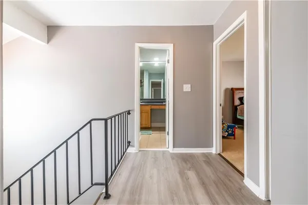 a view of a hallway with wooden floor and closet