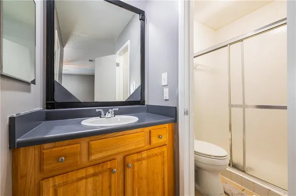 a bathroom with a granite countertop sink mirror vanity and toilet