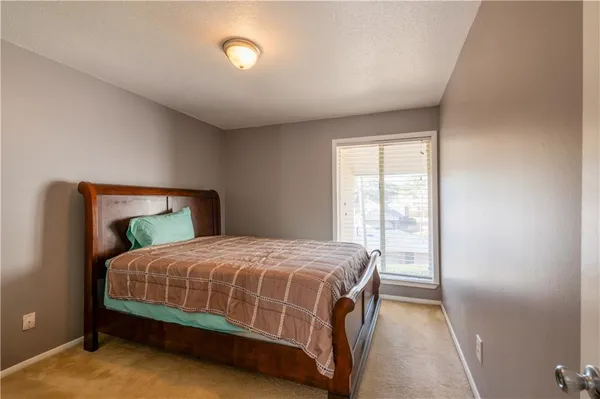 a bedroom with a large bed and a window