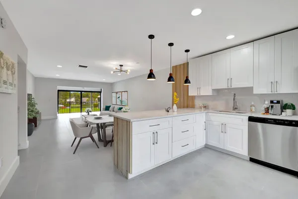 a open kitchen with white cabinets and white appliances
