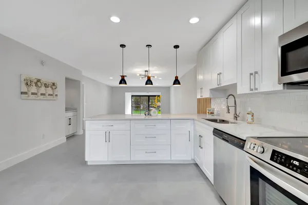 a kitchen with granite countertop a sink a stove and cabinets
