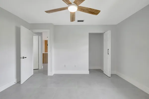an empty room with chandelier fan