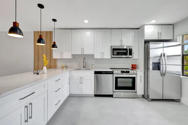 a kitchen with granite countertop white cabinets and stainless steel appliances