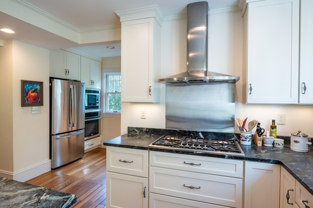 54 Snell Street Amherst, MA 01002 - Photo 27 of 42 a kitchen with granite countertop stainless steel appliances a refrigerator a stove and white cabinets