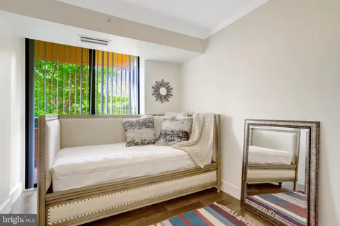 a large white bed sitting in a room next to a window