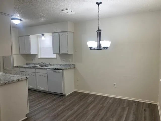 a kitchen with kitchen island granite countertop cabinets and wooden floor