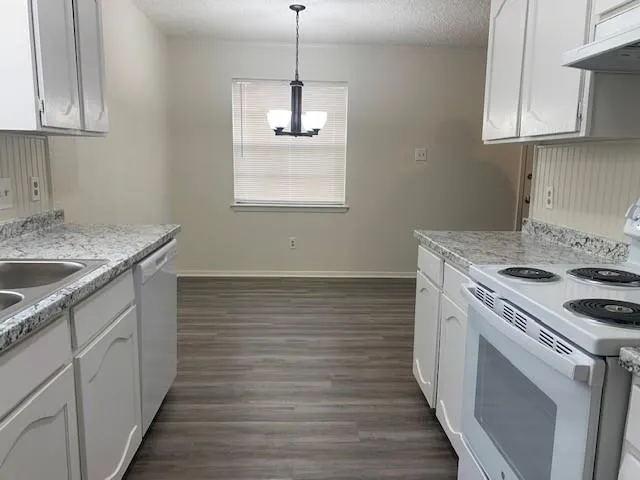 a kitchen with a stove sink and cabinets