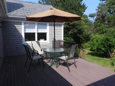 23 Meadowbrook Road Mashpee, MA 02649 - Photo 12 of 20 a patio with wooden floor a yard a table and chairs