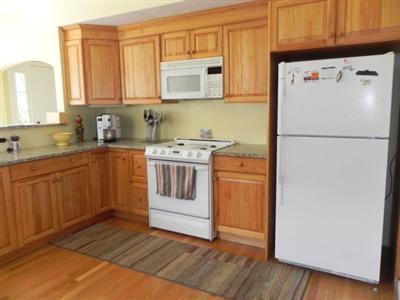 23 Meadowbrook Road Mashpee, MA 02649 - Photo 6 of 20 a white refrigerator freezer sitting inside of a kitchen with stainless steel appliances granite countertop wooden cabinets and a refrigerator