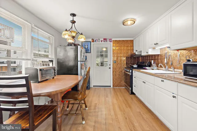 a living room with furniture a dining table and chairs with wooden floor