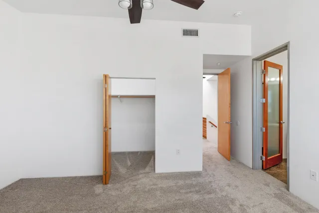 an empty room with closet and windows