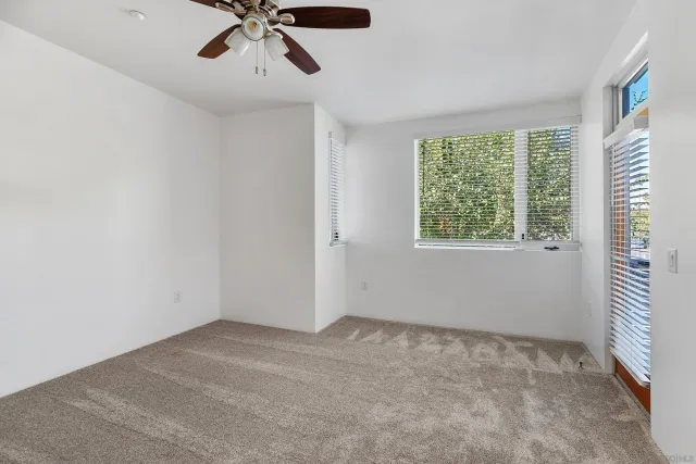 a view of an empty room with window and closet area