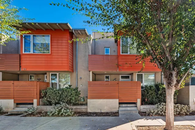 a front view of a house with a tree