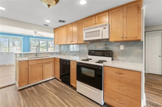 a kitchen with granite countertop a sink a counter space and stainless steel appliances