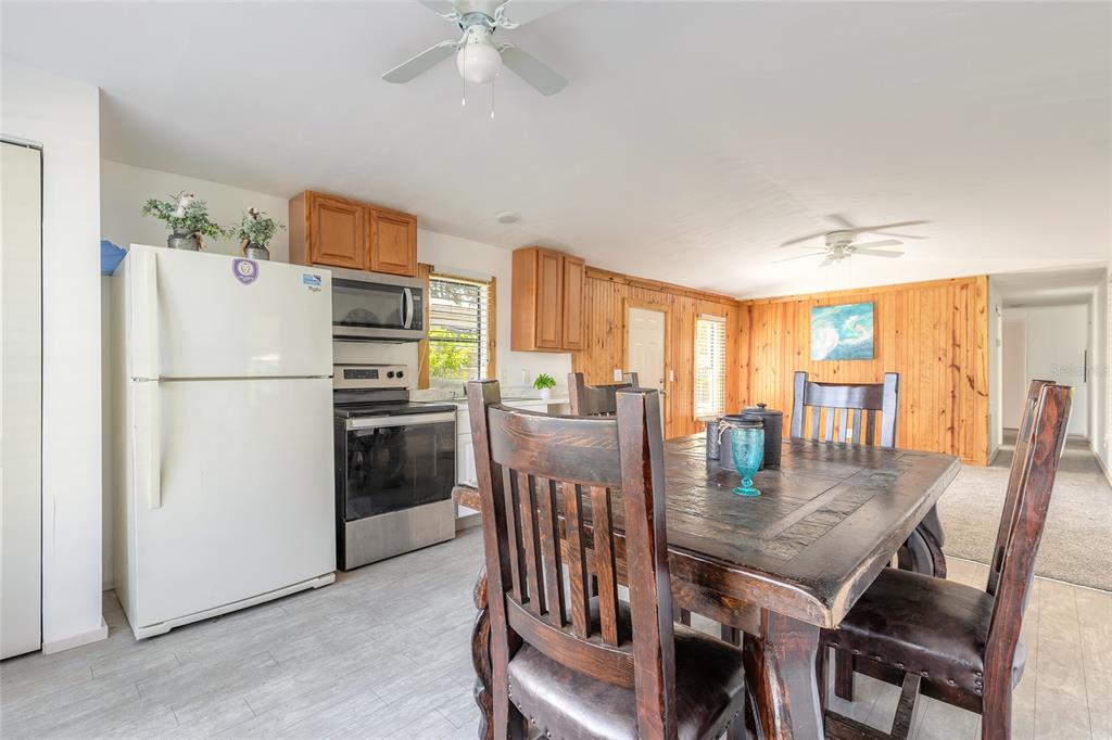 182 Douglas Street Edgewater, FL 32141 - Photo 13 of 30 a kitchen with a refrigerator a stove dining table and chairs