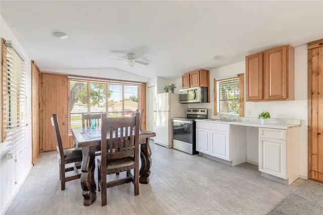 a kitchen with white cabinets and wooden floor