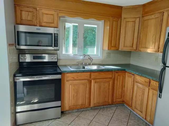 a kitchen with stainless steel appliances granite countertop a stove microwave and sink