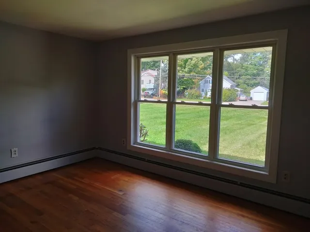 a view of a room with wooden floor and windows