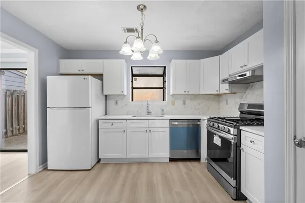 a kitchen with stainless steel appliances granite countertop a refrigerator stove a sink and dishwasher