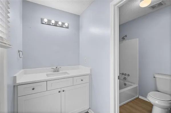 a bathroom with a sink a toilet a mirror and shower