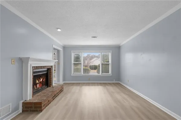 an empty room with fireplace and windows