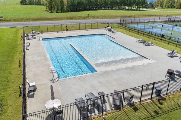 a view of swimming pool with seating space and wooden fence