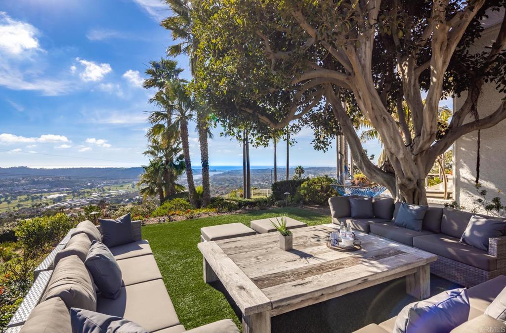 7157 Obelisco Circle Carlsbad, CA 92009 - Photo 11 of 44 a view of a patio with couches table and chairs with plants and lake view