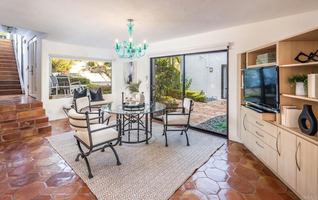 7157 Obelisco Circle Carlsbad, CA 92009 - Photo 27 of 44 a living room with furniture a chandelier and a flat screen tv