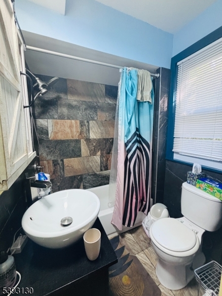 212 4th Street Passaic, NJ 07055 - Photo 7 of 14 a bathroom with a sink a toilet and a mirror