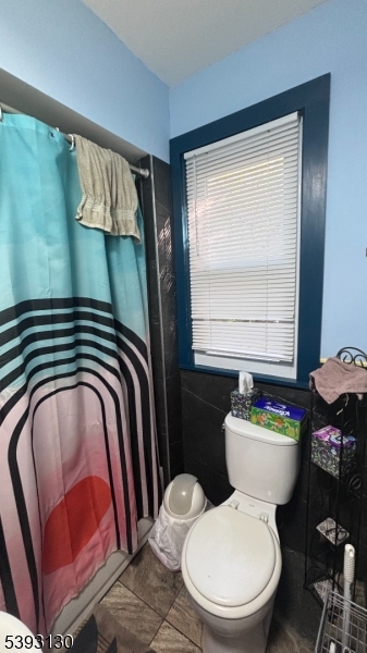 212 4th Street Passaic, NJ 07055 - Photo 9 of 14 a bathroom with a toilet sink and mirror