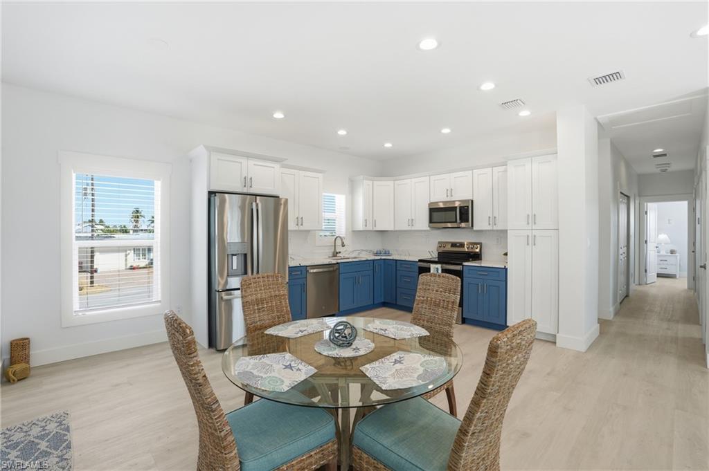 1 Fairview Boulevard Fort Myers Beach, FL 33931 - Photo 10 of 48 a kitchen with stainless steel appliances kitchen island granite countertop a refrigerator and microwave