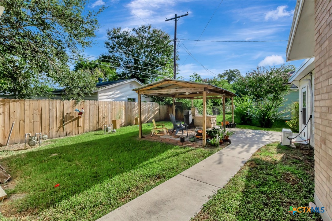 3403 East Rio Grande Street Victoria, TX 77901 - Photo 40 of 41 a view of a patio with table and chairs under an umbrella with wooden fence