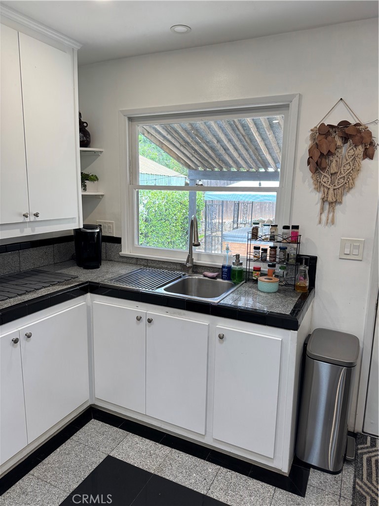 155 Barhaven Lane Fallbrook, CA 92028 - Photo 14 of 43 a kitchen with granite countertop a sink and white cabinets