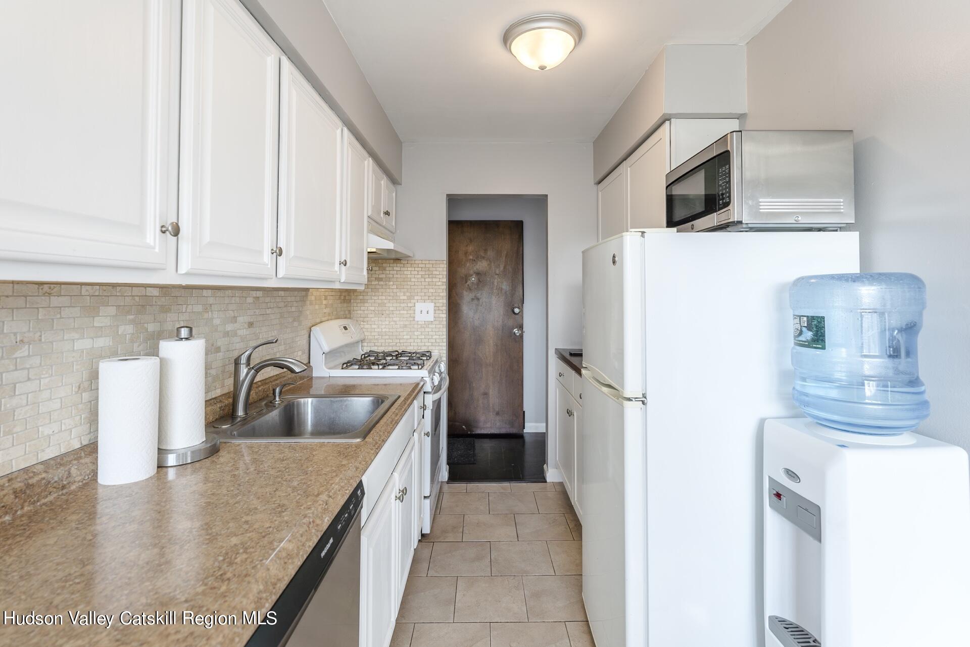 6 Colonial Road, Unit 46 Beacon, NY 12508 - Photo 10 of 19 a kitchen with a refrigerator sink and white cabinets