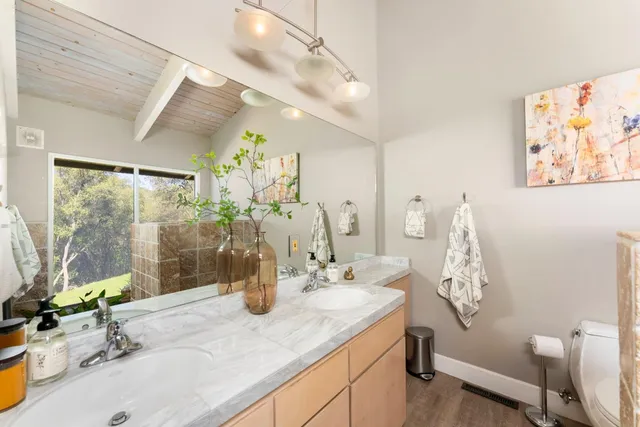 a bathroom with a granite countertop sink a large mirror and a shower