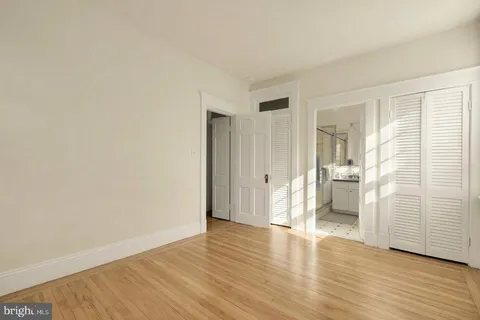 a view of empty room with wooden floor and entryway