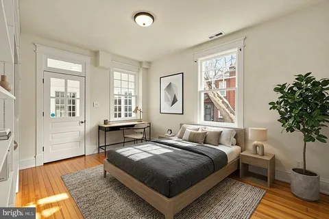 a bedroom with a bed lamp and a potted plant